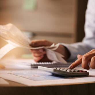 closeup-economist-using-calculator-while-going-through-bills-taxes-office walliscutts